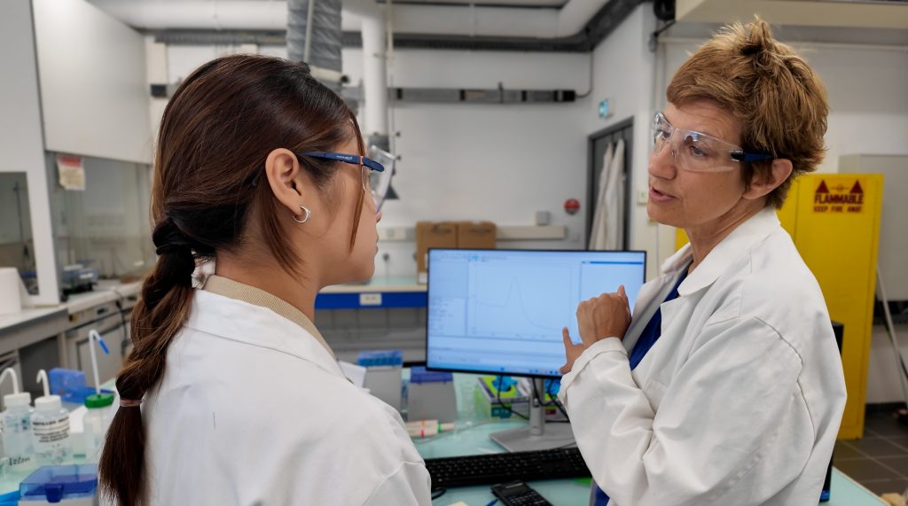deux femmes scientifiques discutent devant un écran pour un documentaire ou film institutionnel authentique pour mettre en valeur leur travail
