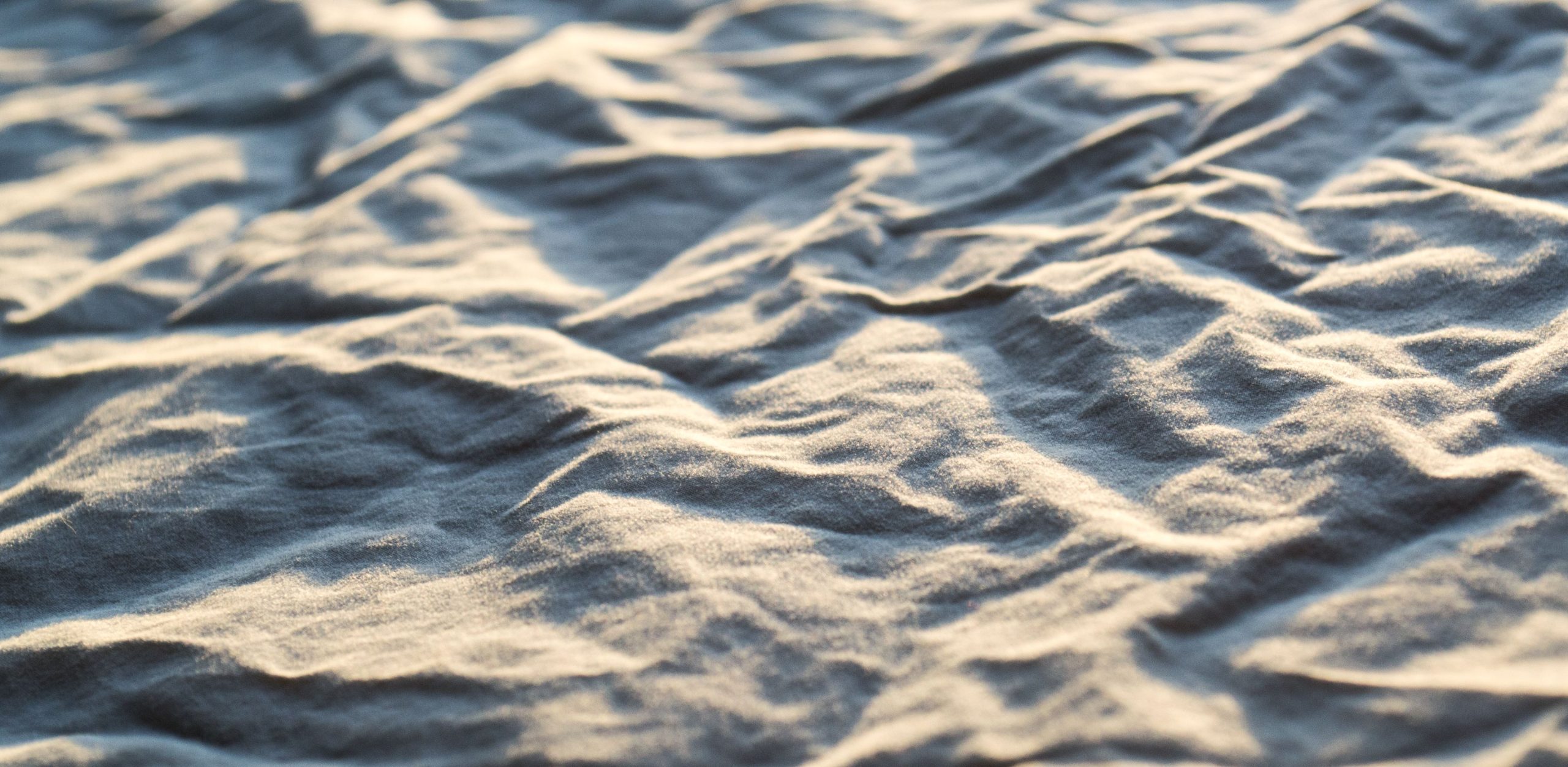 Image de tissu en lin évoquant le sable. Matière naturelle qui rappelle que Relief vous accompagne dans la création d'une communication à votre image, inspirée d'une matière brute : votre identité.